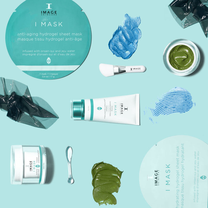 Flat lay of skincare products including jars, tubes, and applicators with blue and green product swatches, showcasing the I MASK purifying probiotic mask | IMAGE Skincare.