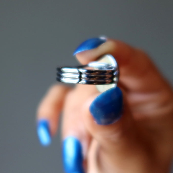 hand holding mahogany obsidian oval in gunmetal adjustable ring
