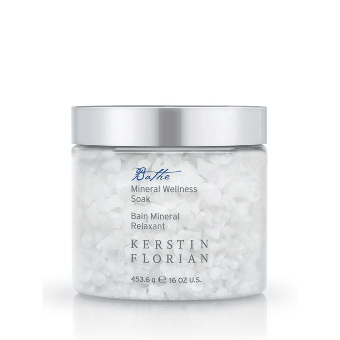 Clear jar of coarse white bath salts labeled Mineral Wellness Soak | Kerstin Florian with a silver lid, designed for skincare and body care wellness routines.