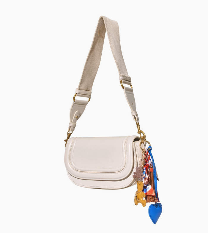 White handbag with colorful charms on a white background