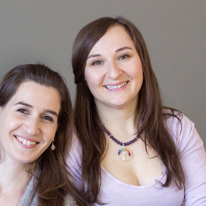 two female models one wearing chakra stone tree of life wire wrapped pendant on beaded amethyst necklace