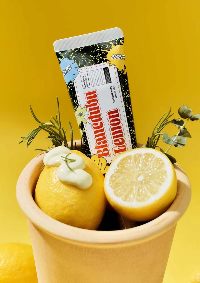 Bar of chocolate labeled 'Blancabu Lemon' with lemons and a container on a yellow background