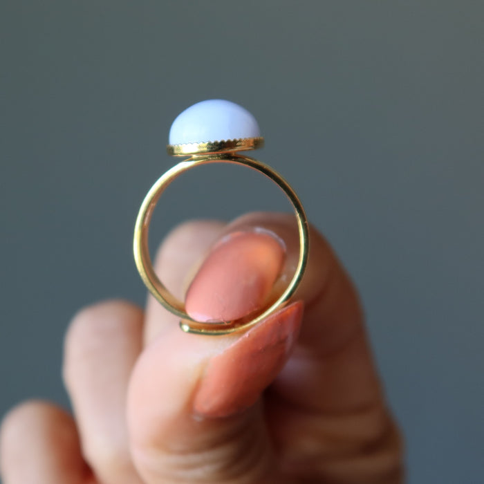 hand holding blue lace agate oval in gold tone adjustable ring