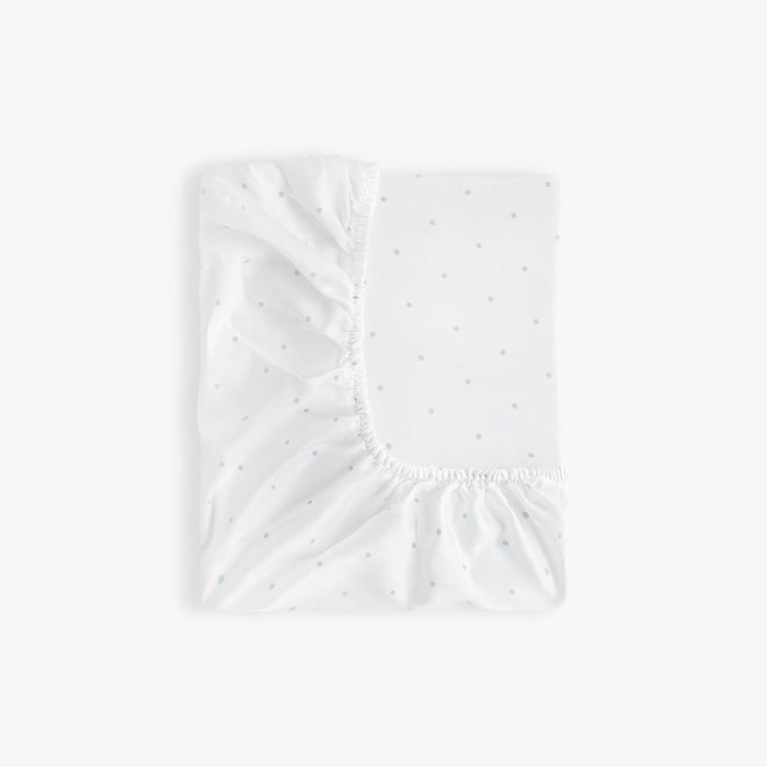 White fitted sheet with blue polka dot pattern on a white background