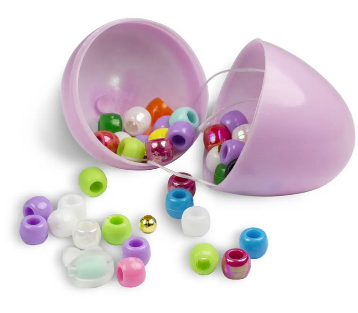 Assorted colorful beads and charms scattered around with an open purple egg-shaped container