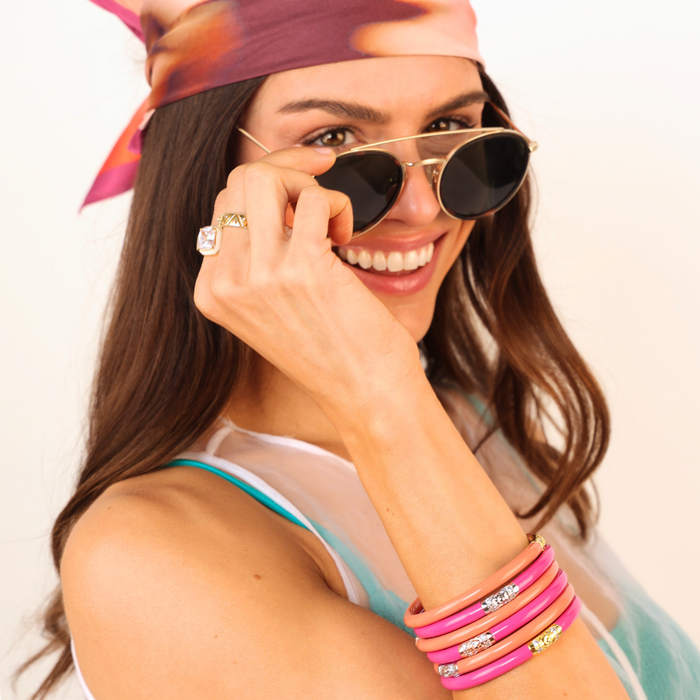 a woman smiling with sunglasses and a bandana