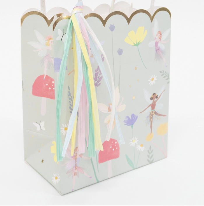 Gift bag with fairy design and ribbons on a white background