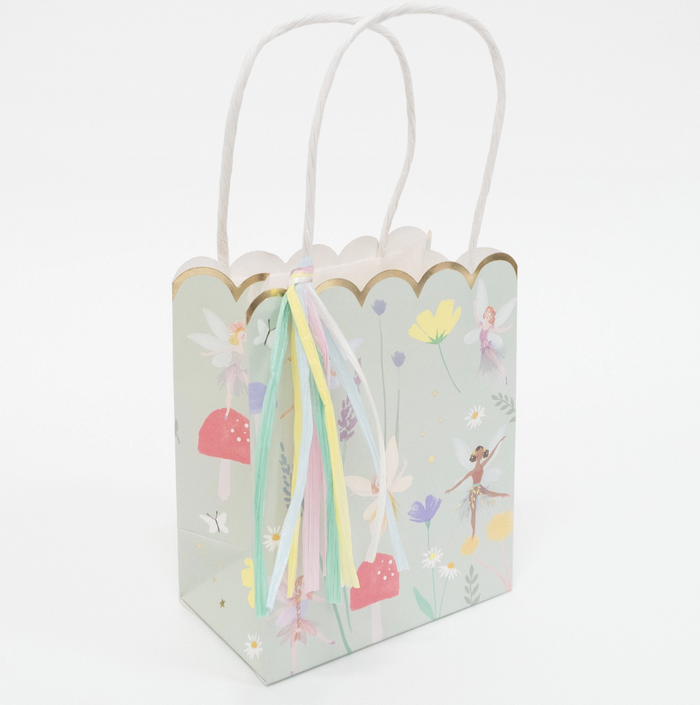 Decorative gift bag with fairy design and colorful ribbons on a white background