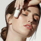 Woman applying Glow Time Highlighter Stick | Jane Iredale to her cheek, highlighting radiant, glowing skin in natural light.