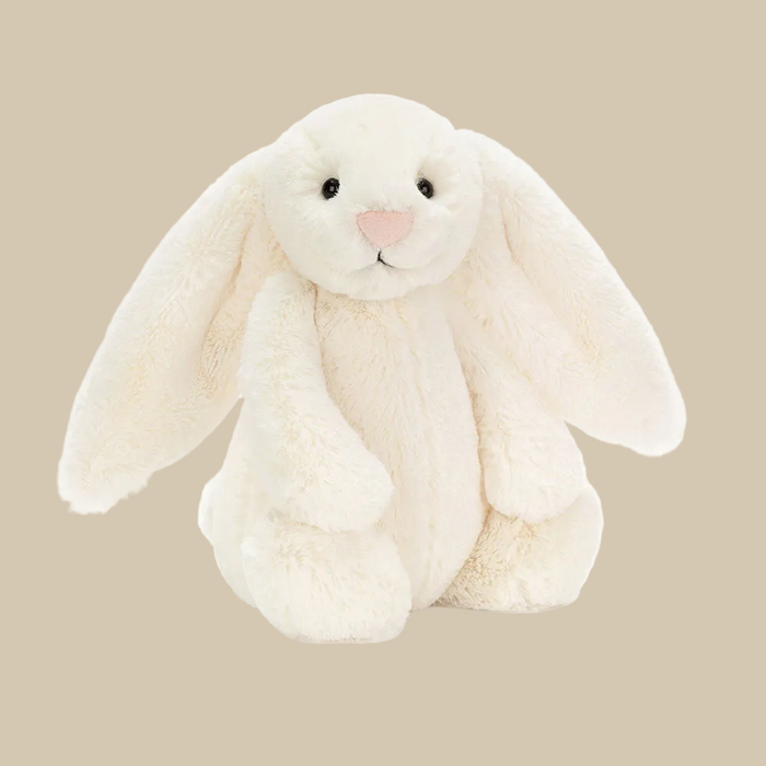 White plush bunny toy on a beige background