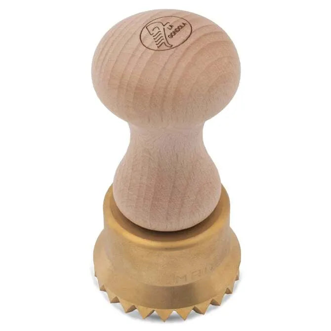 A wooden handle pasta stamp with brass components, featuring apparent flaws as part of its artisan production on a white background.