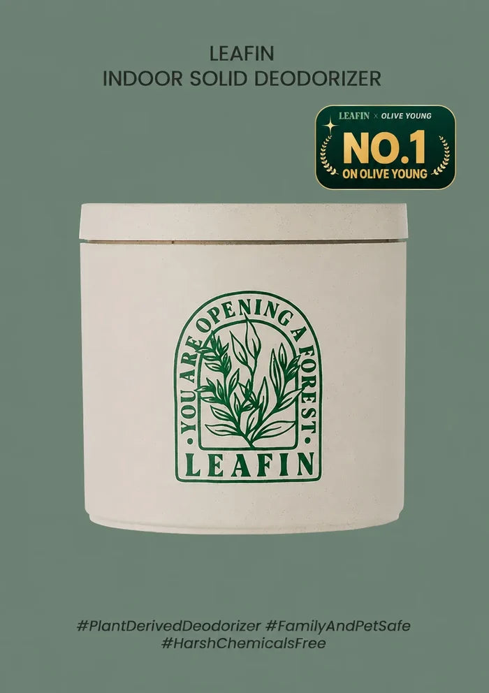 A white cylindrical tin of LEAFIN Indoor Solid Deodorizer on a muted sage green background. The tin features a green botanical logo with the text 'You Are Opening a Forest' and 'LEAFIN'.