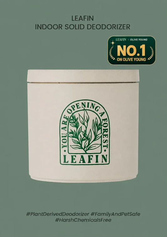 A white cylindrical tin of LEAFIN Indoor Solid Deodorizer on a muted sage green background. The tin features a green botanical logo with the text 'You Are Opening a Forest' and 'LEAFIN'.