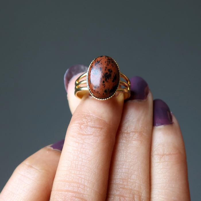 hand holding mahogany obsidian gold ring