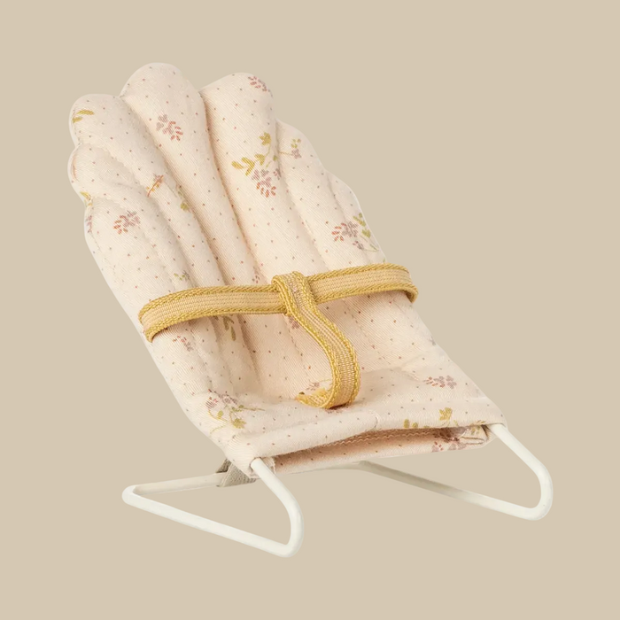 Baby swing with floral patterned seat cover on a white background