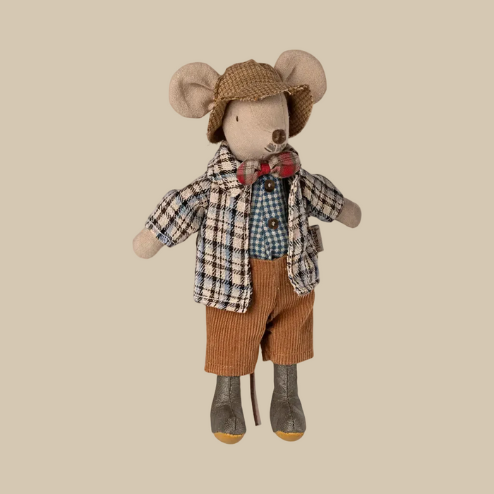 Stuffed toy mouse dressed in a plaid shirt, bow tie, and brown pants on a white background