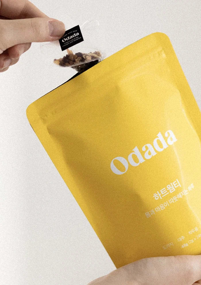 Yellow package with 'Odada' branding held by a hand against a white background