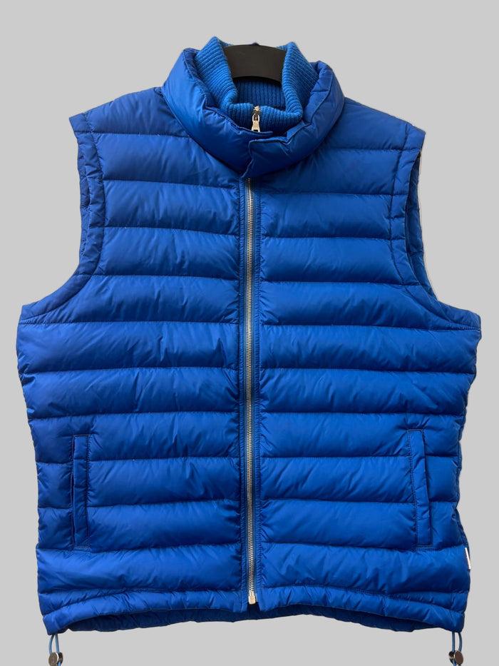 Blue puffer vest on a beige background