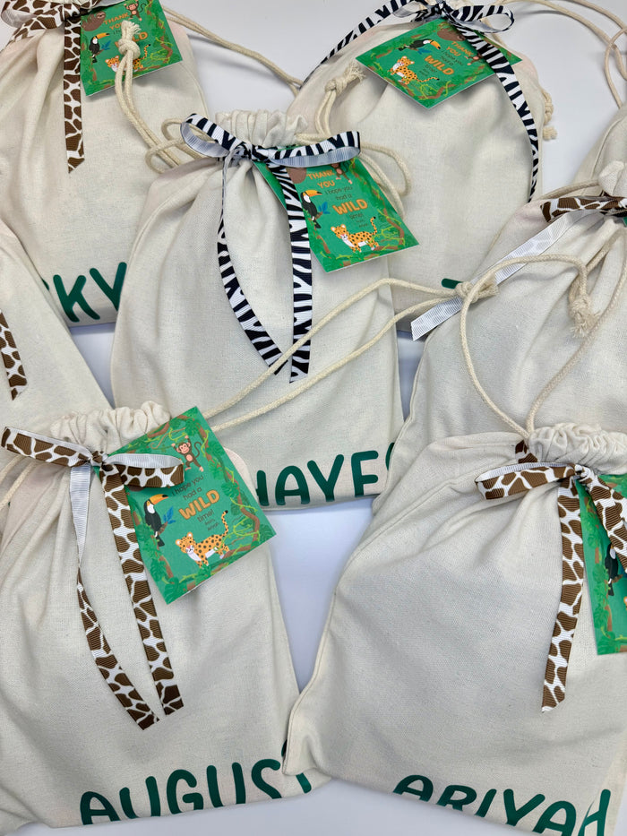 White drawstring bags with animal print accents and green tags on a white background