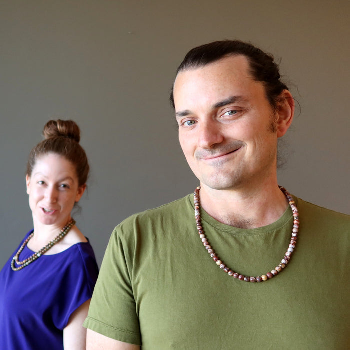 female and male wearing birds eye rhyolite necklaces
