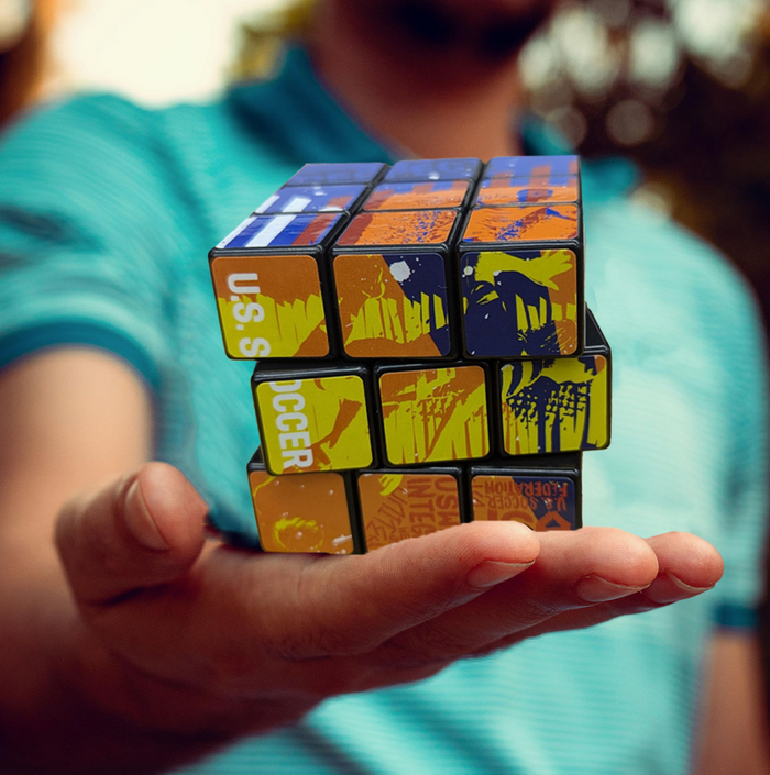 Person holding a Rubik's Cube with colorful stickers