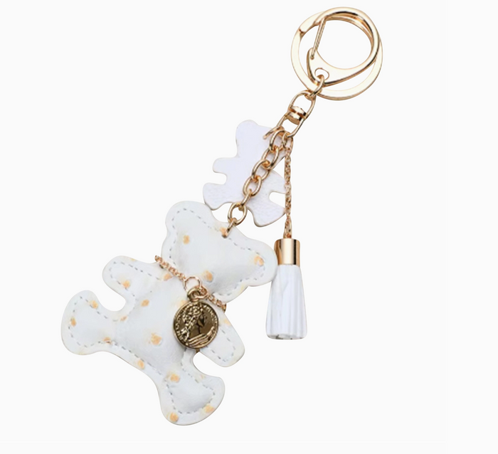 White bear-shaped keychain with gold accents on a white background