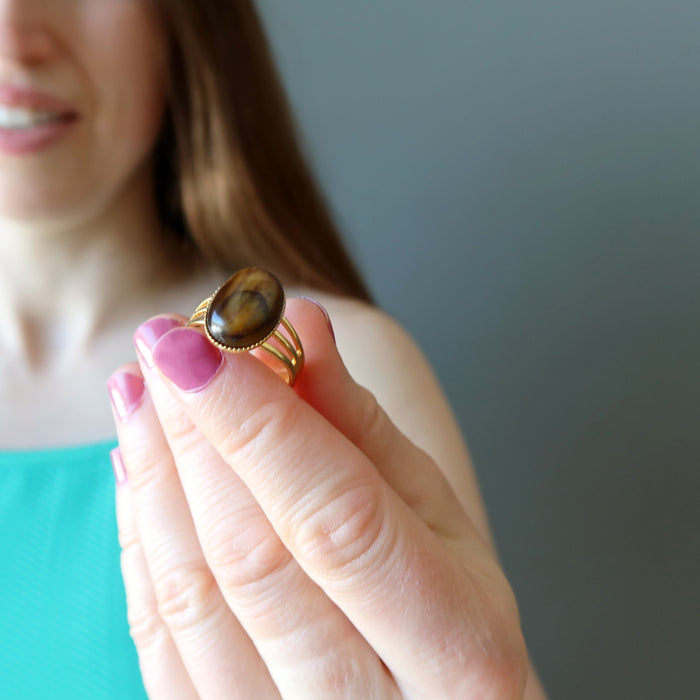 female model holding tigers eye gold ring