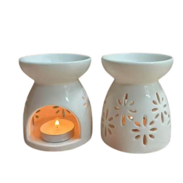 White ceramic oil burners with one lit candle inside on a white background